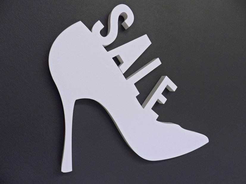 3D-Piktogramm SALE Schuh aus XPS-Schaum, konturgeschnitten und mit Magnetbefestigung auf Eisenfarbenwand.